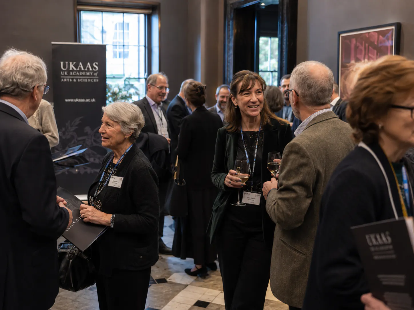 Participants in conversation at an Academy reception